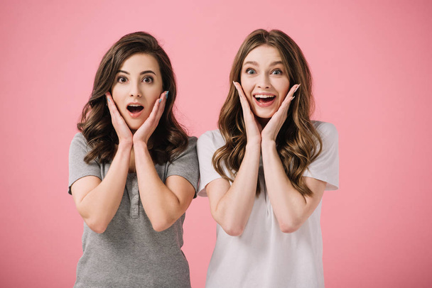 attractive and shocked women in t-shirts looking at camera isolated on pink - Photo, Image