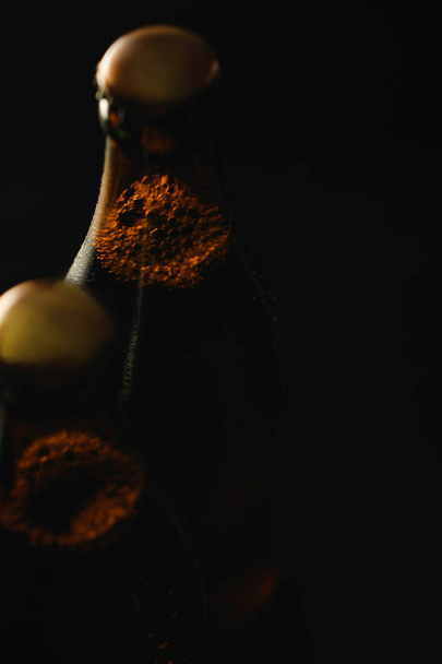 vista de cerca de botellas de vidrio de cerveza con burbujas aisladas en negro
 - Foto, Imagen