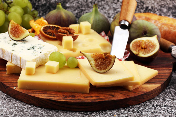 Bandeja de queso con diferentes quesos y uvas e higos y frutos secos
 - Foto, Imagen