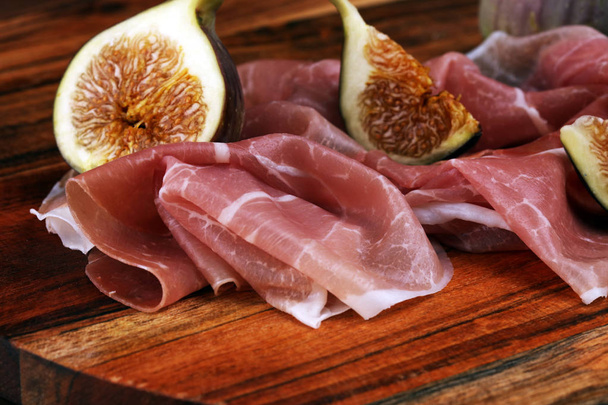 Italiaanse prosciutto crudo of Jamon met gesneden vijgen rauwe ham. - Foto, afbeelding
