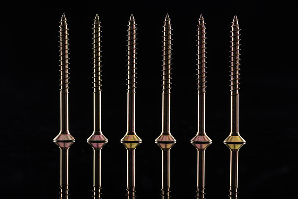row of new shiny metallic screws isolated on black - Φωτογραφία, εικόνα