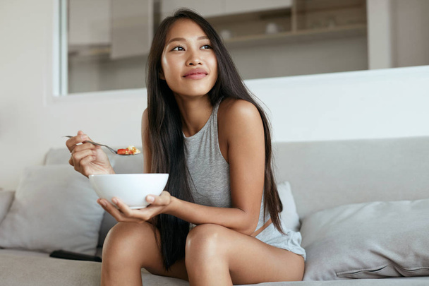 Smiling woman eating healthy breakfast at home in morning - Foto, Imagem