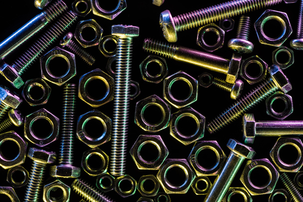 top view of scattered metallic bolts and nuts isolated on black - Фото, изображение