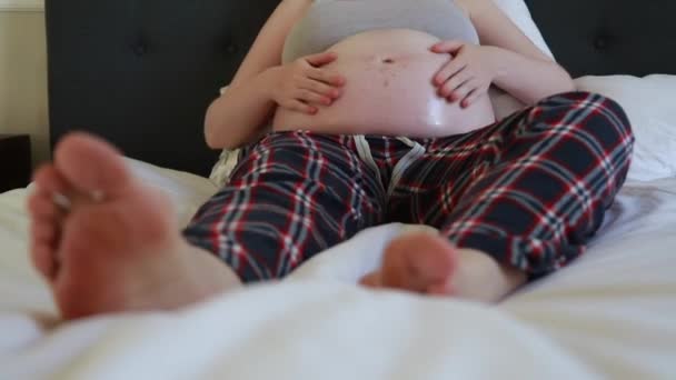 Raskaana oleva nainen hieromassa öljyä vatsaansa pysäyttääkseen raskausarpia
 - Materiaali, video