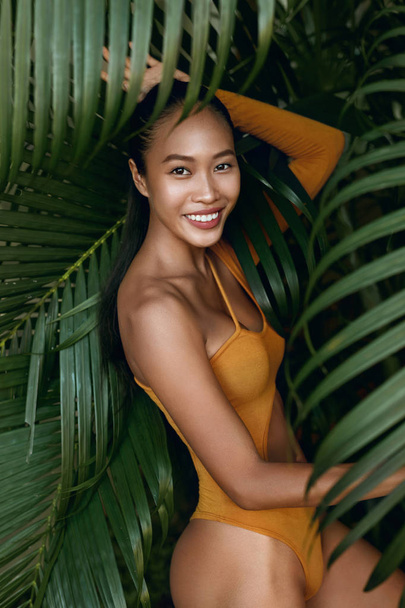 Summer fashion. Happy woman model in swimsuit at tropical nature - Φωτογραφία, εικόνα