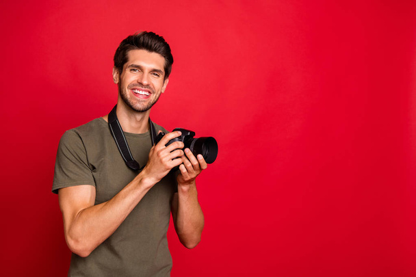 Photo of amazing guy with photo digicam making pictures wear casual grey t-shirt isolated on red background - Foto, afbeelding