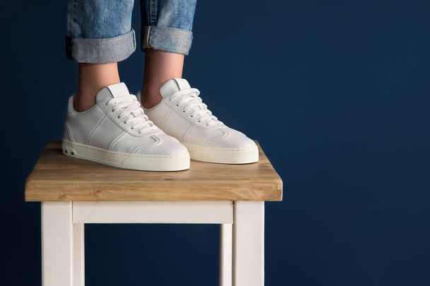White sneakers on the legs of the girl. - 写真・画像