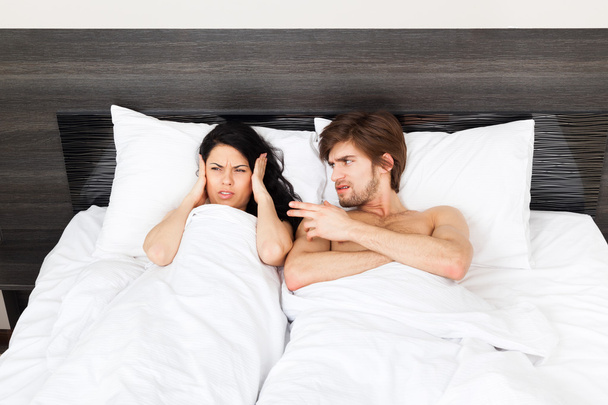 Unhappy couple lying in a bed - Photo, image