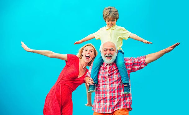 Family generation and relations concept. Concept of friendly family. Grandfather and little grandson with mother playing on blue summer sky. - Foto, Imagem
