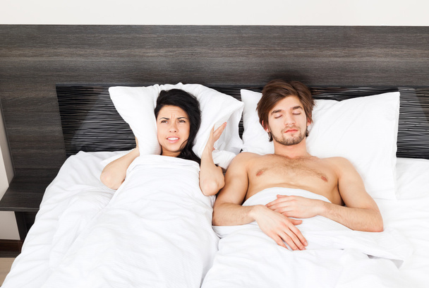 Couple in bed, snoring man - 写真・画像