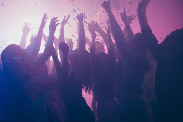 Close up photo of many festive excited people dancing clubbing purple lights confetti fog nightclub hands raised shiny formal-wear - Foto, Imagem