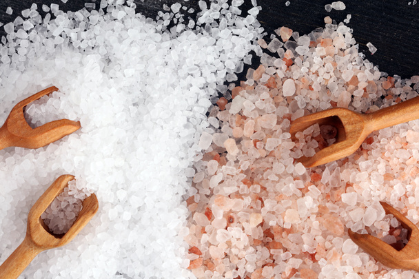 Sal marina e himalaya en cuchara. Cristales de sal sobre fondo oscuro
 - Foto, imagen