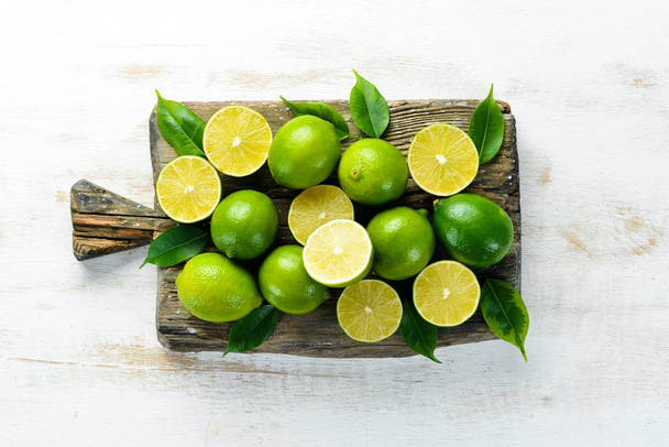 Green limes on white wooden background. Fruits. Top view. Free space for your text. - Photo, image