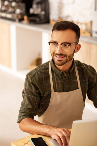 Entrepreneur owning coffee shop smiling while having new ideas - Photo, Image