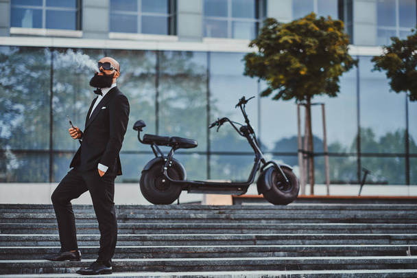 Człowiek pozuje w pobliżu jego nowoczesnego Electro Bike - Zdjęcie, obraz
