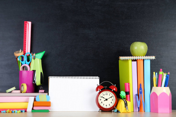 School supplies with blank sheet of paper on blackboard backgrou - Фото, изображение