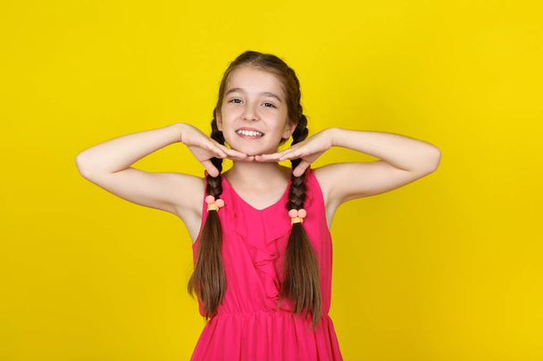Beautiful young girl in pink dress on yellow background - Foto, Imagem