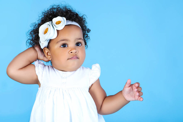 Beautiful baby girl in white dress on blue background - Photo, Image