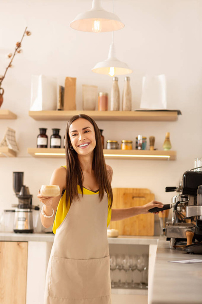 Barista smiling while talking to customer and making coffee - 写真・画像