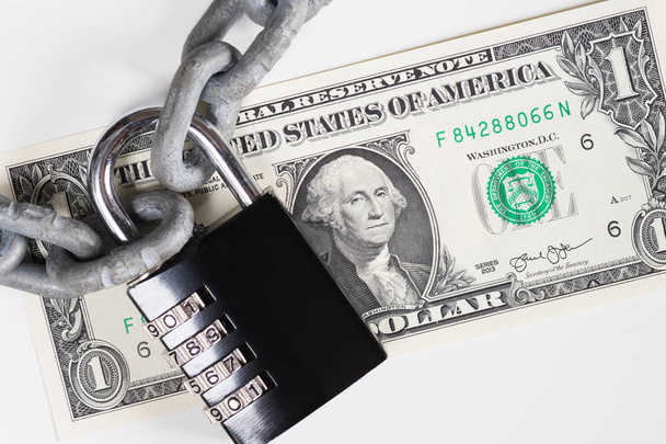 Closeup of one US Dollar banknote under metallic chain and padlock - Photo, Image