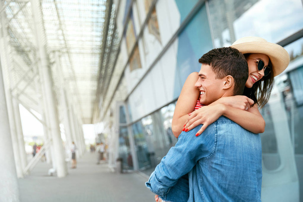 久しぶりに出会うカップル。空港近くで抱き合う幸せな人々 - 写真・画像