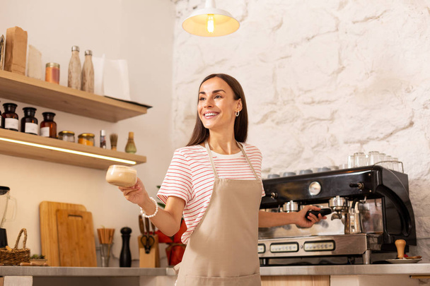 Ευχάριστο μπάρμαν χαμογελώντας ενώ δίνει καφέ στον πελάτη - Φωτογραφία, εικόνα