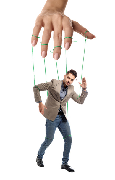 Ręka Lalkarz manipulując człowiekiem jako Marionette na białym tle - Zdjęcie, obraz