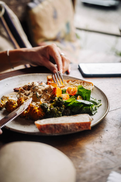 Woman having hearty breakfast with curry veggies - Photo, Image