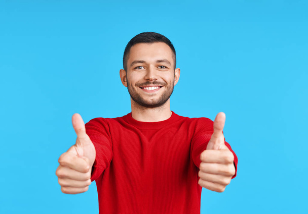 Happy handsome man showing thumbs up sign on blue background. Good idea concept             - Fotografie, Obrázek
