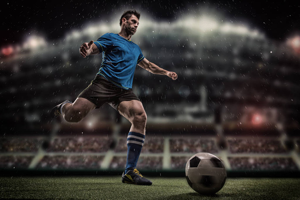 voetbal-speler met bal op gebied van stadion - Foto, afbeelding