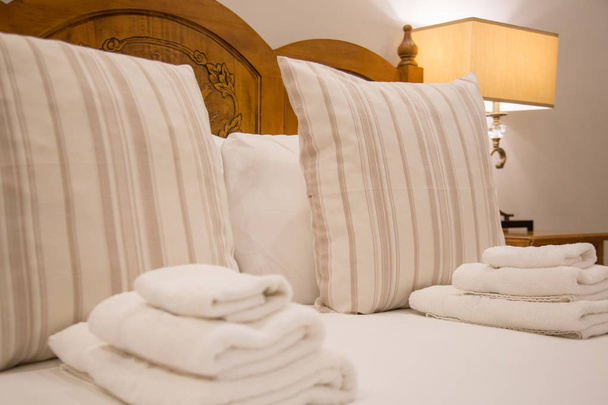 Καθαρές πετσέτες σε κρεβάτι σε σουίτα ξενοδοχείου - Φωτογραφία, εικόνα