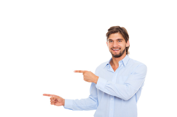 Komea nuori liikemies onnellinen hymy osoittaa sormella tyhjään kopioi tilaa
 - Valokuva, kuva