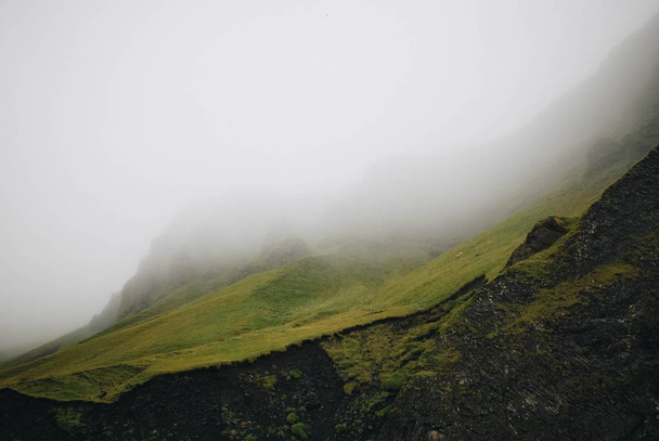 A beautiful shot of a grassy mountain in a fog - Foto, imagen