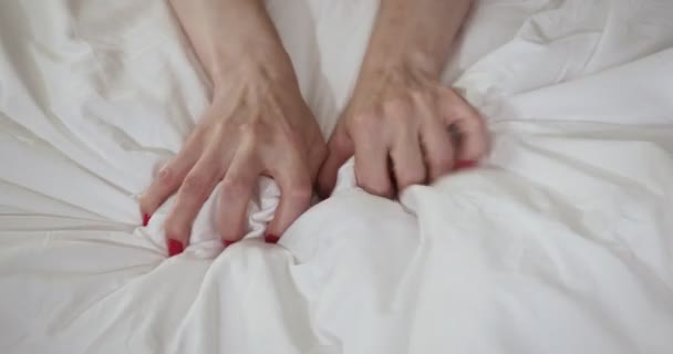 Mujer mano con sexo orgasmo en blanco cama
. - Imágenes, Vídeo