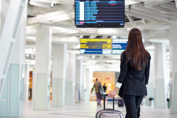 Young asian business woman in airport with trolley bag, waiting for departure - Fotografie, Obrázek