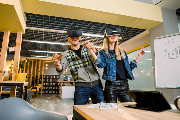 business people, young hipster couple at modern office indoors have fun wearing virtual reality headset - Foto, immagini