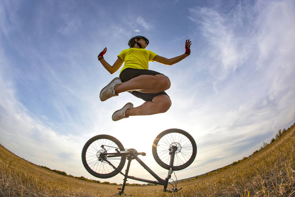 ciclista chica salta al cielo en el fondo de la moto
 - Foto, Imagen