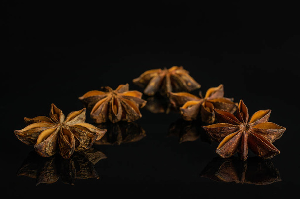 Dry star anise isolated on black glass - Photo, Image