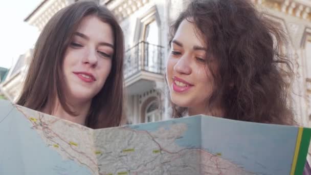 Oříznutý záběr dvou mladých žen s použitím mapy - Záběry, video
