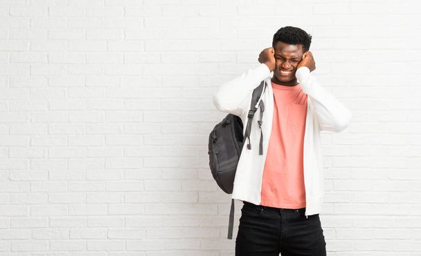 Young afro american man student covering both ears with hands. Frustrated expression - Fotoğraf, Görsel