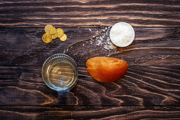 Ένα ποτήρι νερό και ένα κομμάτι ψωμί στο τραπέζι μπροστά από τ - Φωτογραφία, εικόνα