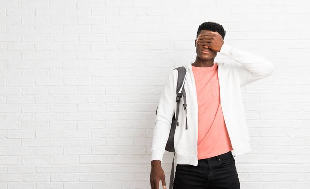 Young afro american man student covering eyes by hands. Do not want to see something - Photo, Image