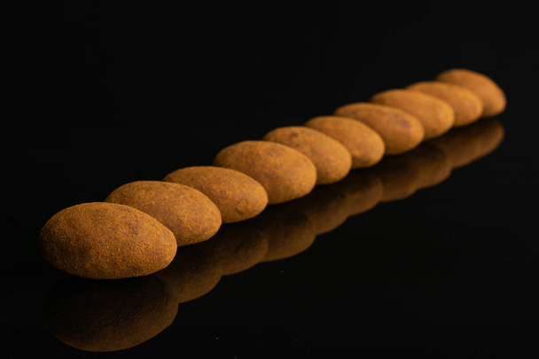 Chocolate cinnamon almond isolated on black glass - Fotografie, Obrázek