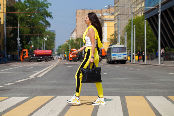 Portrait of a young beautiful brunette woman in yellow tracksuit - Foto, afbeelding