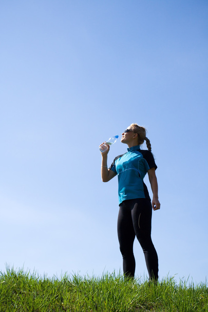 junge Frau trinkt Wasser nach dem Laufen - Foto, Bild