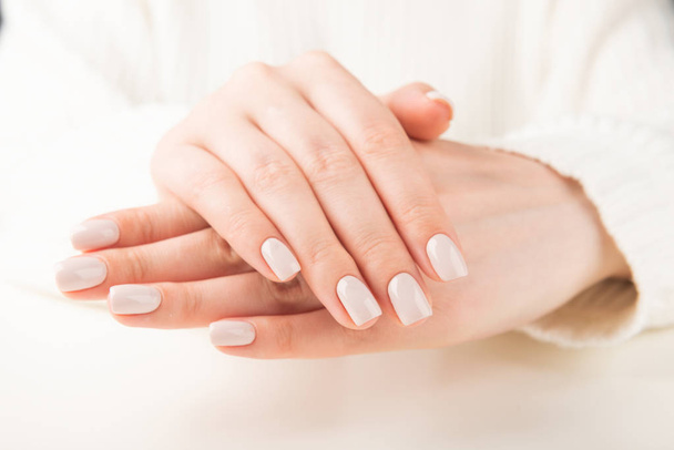 Beautiful female hand with beige nail design - Foto, Imagem