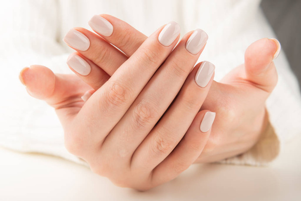 Main féminine avec motif d'ongles beige
 - Photo, image