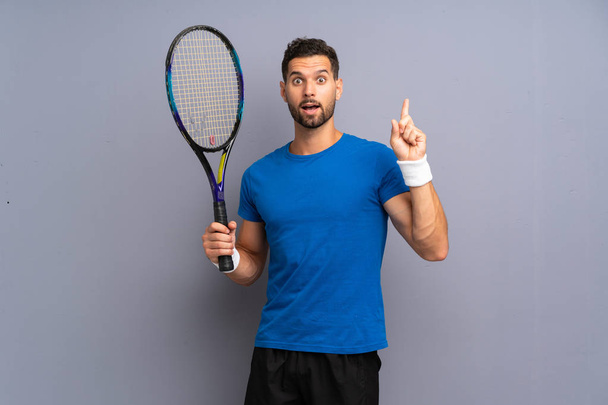 Handsome young tennis player man intending to realizes the solution while lifting a finger up - Photo, Image