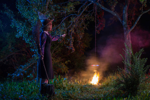 jovem bruxa pelo fogo na floresta noturna
  - Foto, Imagem