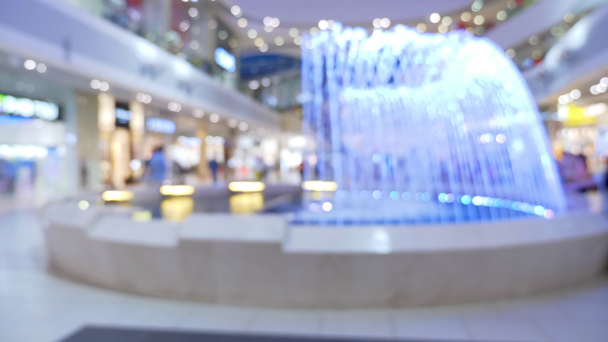 blurred background fountain in the supermarket and people. Abstract bokeh background. textures for fashion. - Footage, Video